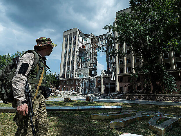 Ein ukrainischer Soldat steht vor dem Gebäude der regionalen Militärverwaltung in Mykolaiv, das bei einem russischen Angriff zerstört wurde. Foto: Evgeniy Maloletka/AP/dpa