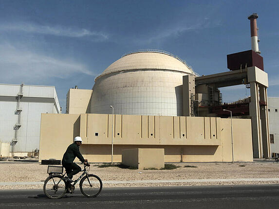 ARCHIV - Ein Mann fährt mit dem Fahrrad an dem Reaktorgebäude des Kernkraftwerks Bushehr vorbei. Foto: Majid Asgaripour/AP/dpa