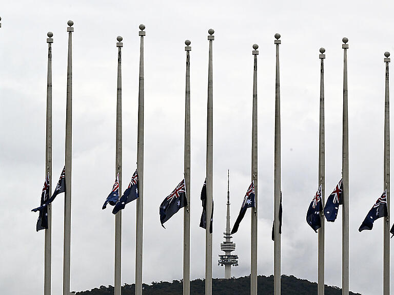 Australian flags are seen at half mast at Parliament House in Canberra, Friday, September 9, 2022. Queen Elizabeth II has died peacefully at Balmoral Palace in Scotland after more than seven decades on the throne. (AAP Image/Mick Tsikas) NO ARCHIVING
