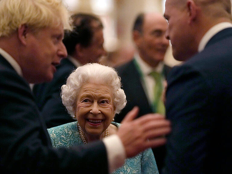 ARCHIV - Die britische Königin Elizabeth II. und Premierminister Boris Johnson (l) begrüßen die Gäste bei einem Empfang anlässlich des Global Investment Summit in Windsor Castle. Foto: Alastair Grant/AP Pool/dpa